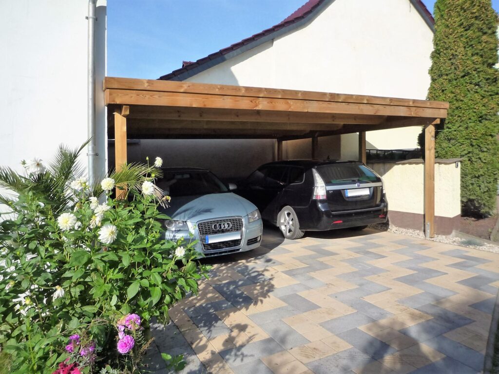 Flachdach-Doppelcarport mit Holzblende neben Haus
