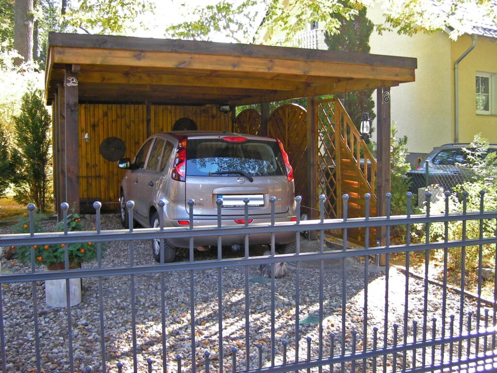 Flachdach-Einzelcarport mit zweireihiger Holzblende seitlich mit Sichtschutz