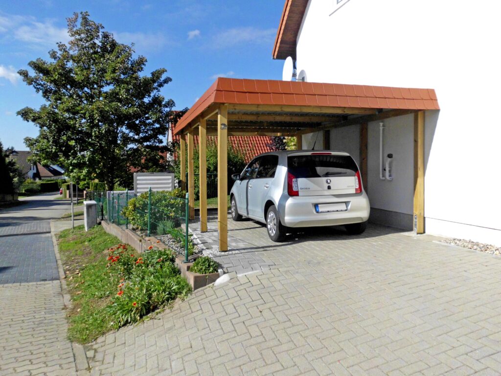 Flachdach-Einzelcarport aus Holz mit warmer roter Schindelblende