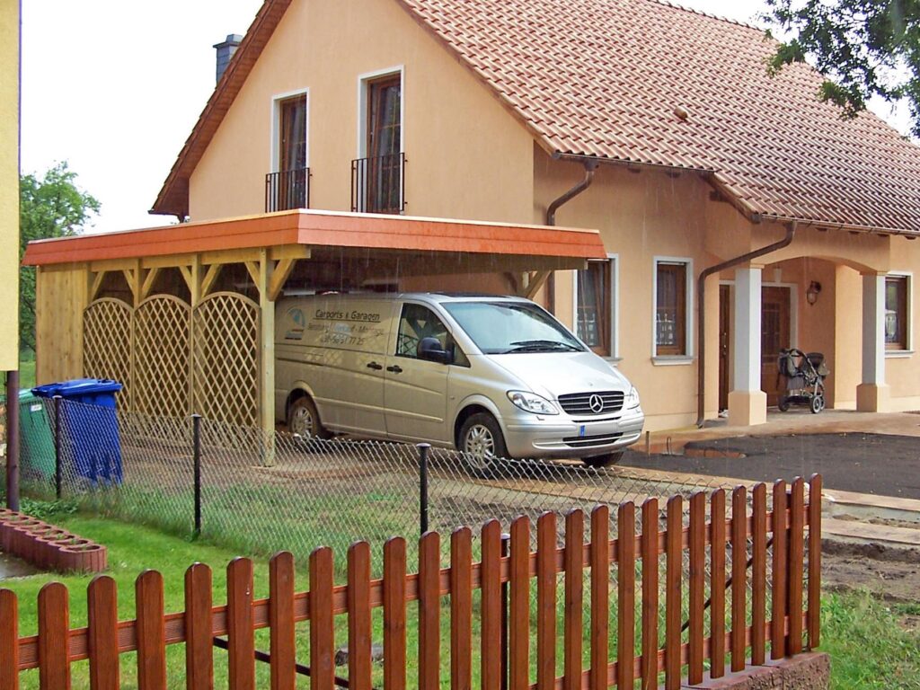 Flachdach-Einzelcarport aus Holz mit roter Schindelblende und Abstellraum