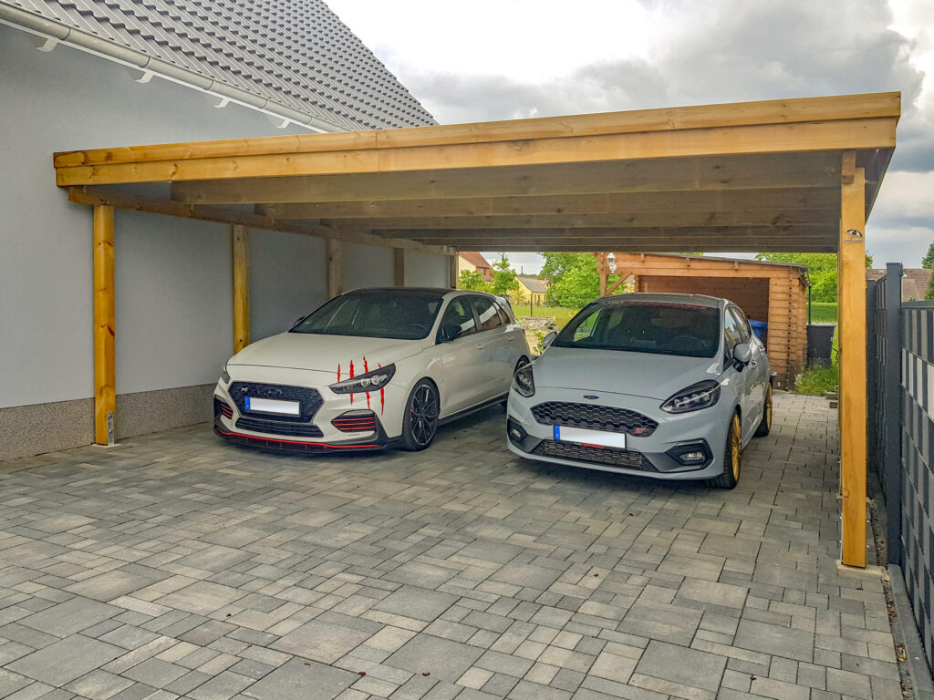 Flachdach-Carport aus Holz für 2 PKW, seitlich am Haus platziert