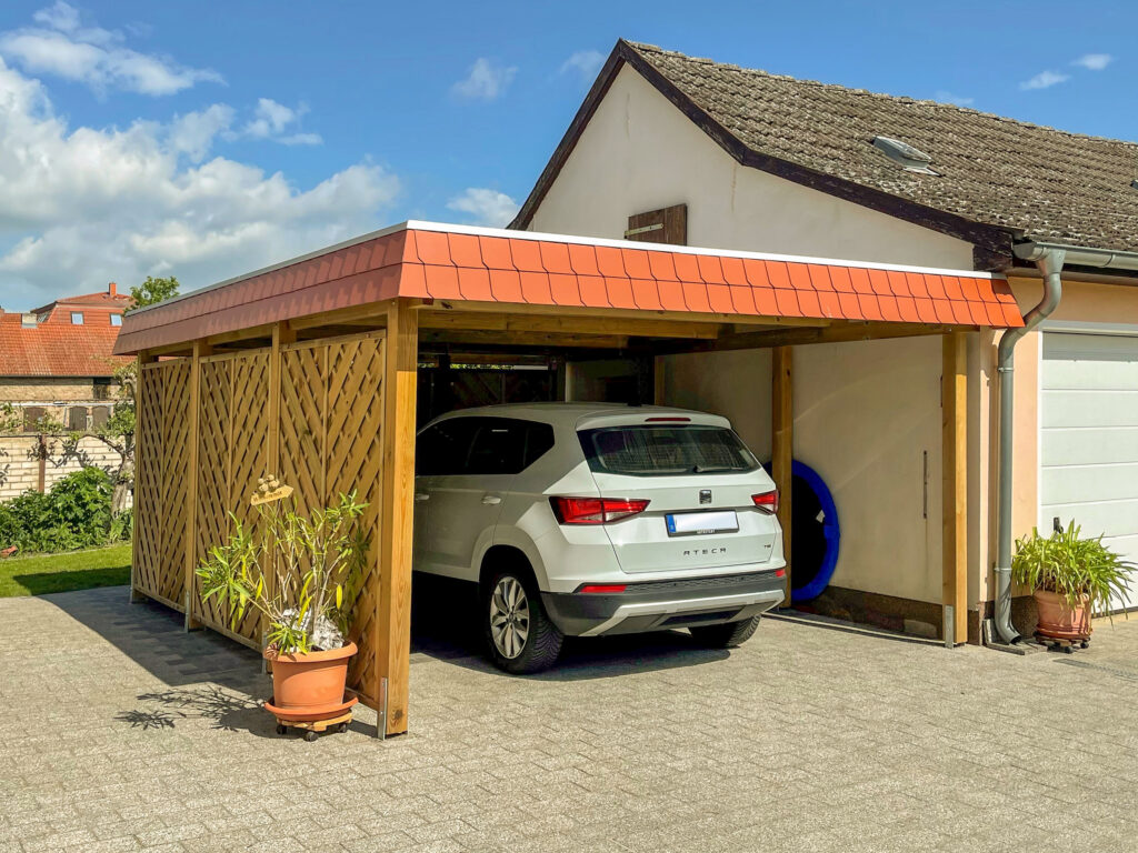 Flachdach-Carport für einen PKW mit markanter Schindelblende
