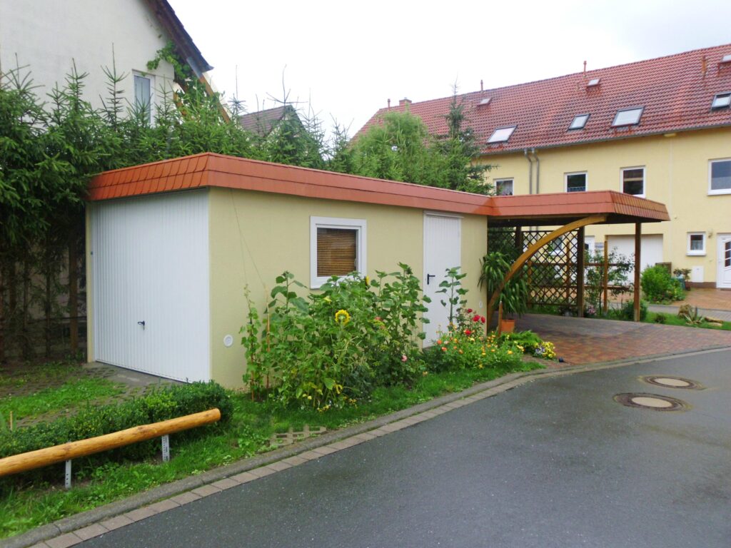 Individuell gefertigter Anbaucarport aus Holz mit integrierter Fertiggarage, perfekt auf das Grundstück abgestimmt
