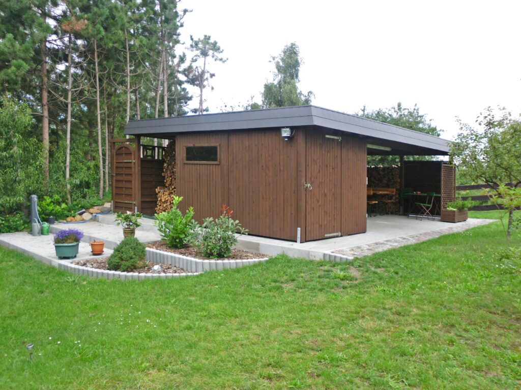 Maßangefertigter Holzcarport mit integriertem Abstellraum im Garten