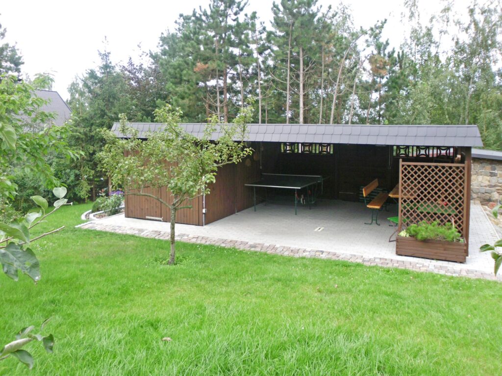Maßgeschneiderter Carport aus Holz im idyllischen Garten, zeigt Möglichkeiten der individuellen Planung