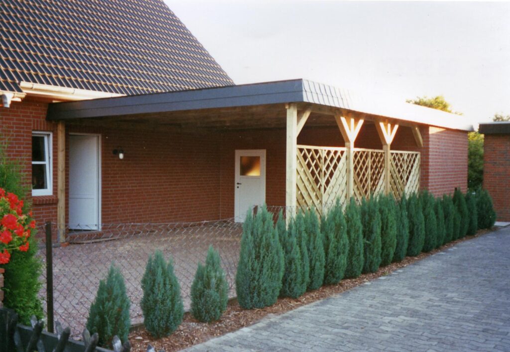 Maßgefertigter Holzcarport als Anbau an einem Wohnhaus mit seitlichem Sichtschutzgitter