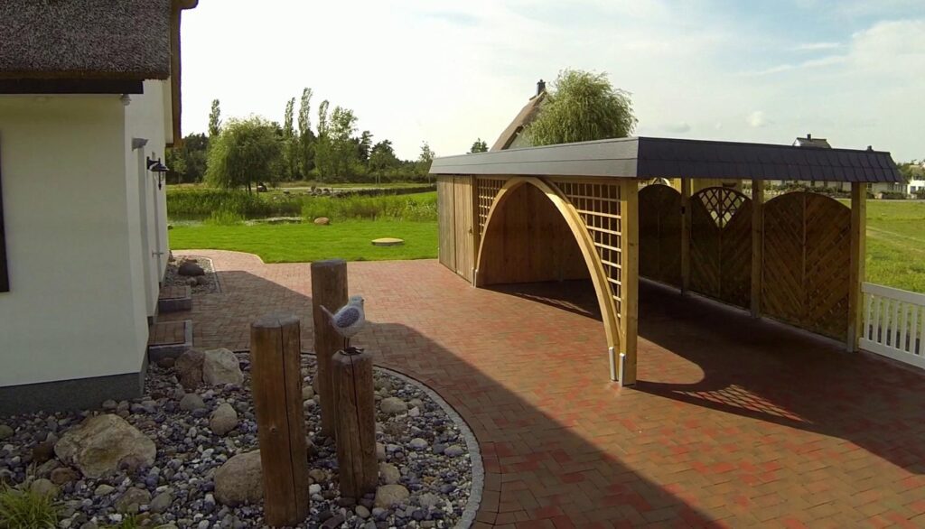 Rundbogen-Einzelcarport mit markantem Bogengang und seitlichem Windschutz