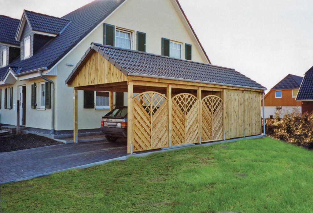 Spitzdach Einzelcarport mit dunklen Dachsteinen und Abstellkammer