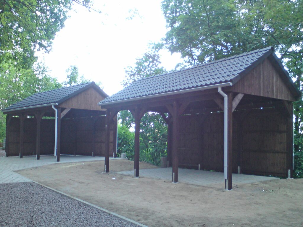 Spitzdach Einzelcarports mit dunklen Dachsteinen und Sichtschutz